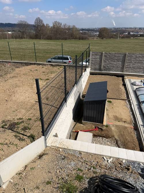 Antracitový 3D panel osazený na betonové podezdívce u novostavby